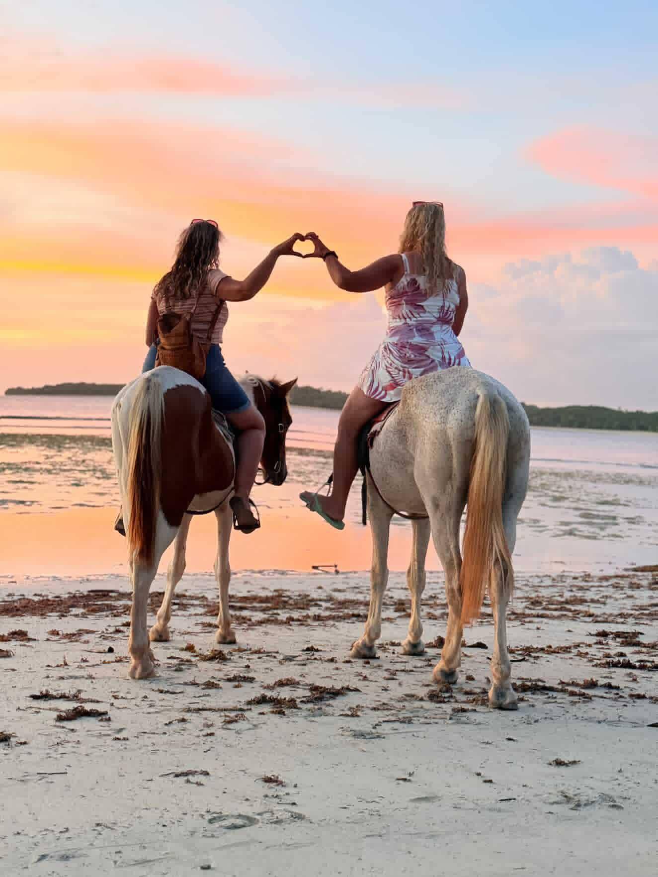 Riders on horseback along a tropical beach in Fiji