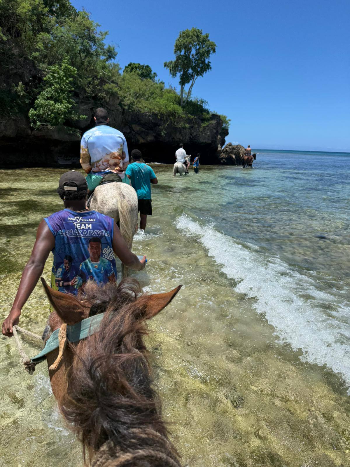 Horses riding through coastal landscape with sea views